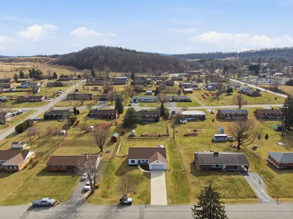 an aerial view of residential building with parking and yard