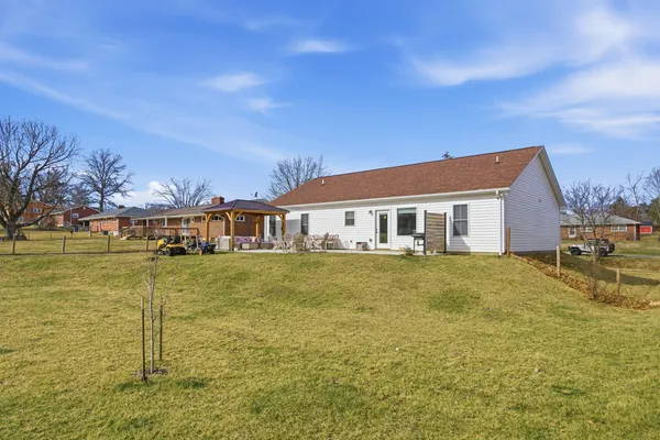 a view of a house with pool and a yard