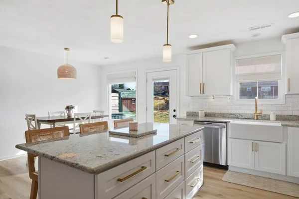 a kitchen with granite countertop a sink a counter space appliances and cabinets