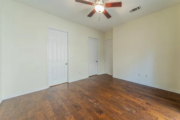 a view of an empty room with a chandelier fan