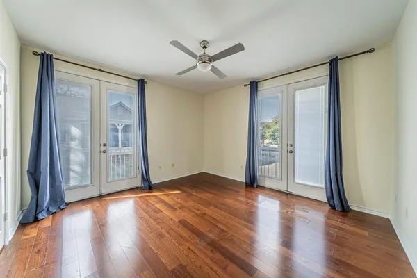 an empty room with wooden floor and windows
