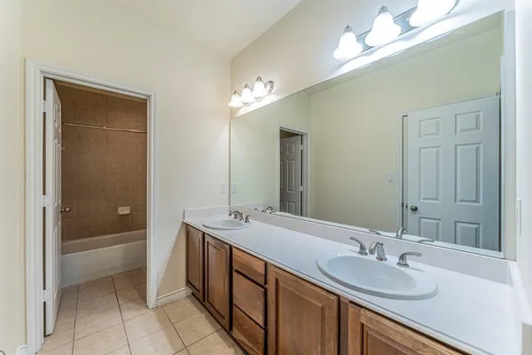 a spacious bathroom with a sink double vanity granite tub and shower