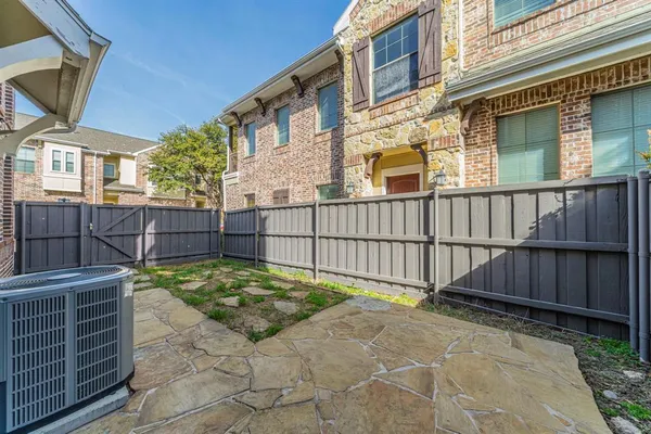 a view of a backyard with a fence and wooden fence