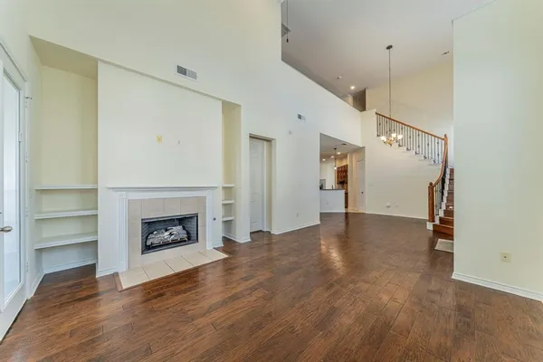 a view of empty room with wooden floor and fireplace
