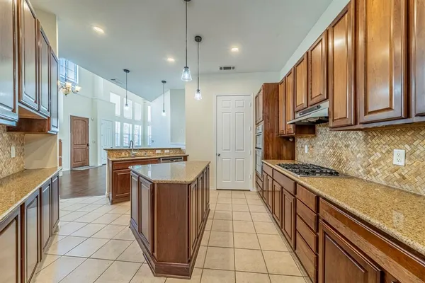 a kitchen with stainless steel appliances granite countertop a stove a sink and a refrigerator