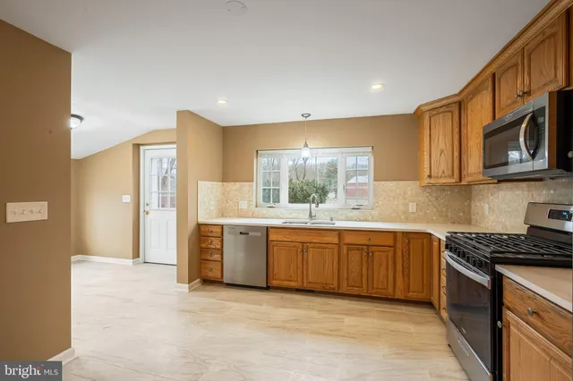 a kitchen with stainless steel appliances granite countertop a stove a sink and a refrigerator