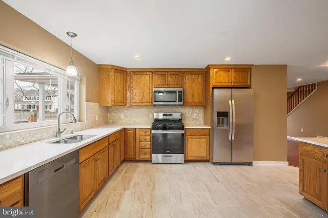 a kitchen with stainless steel appliances granite countertop a refrigerator sink and stove