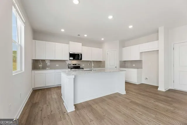 a kitchen with granite countertop a refrigerator stove top oven and sink