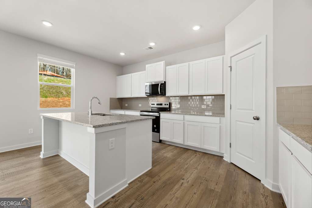 5420 Aurora Trail Flowery Branch, GA 30542 - Photo 14 of 38 a kitchen with granite countertop a refrigerator stove top oven and sink
