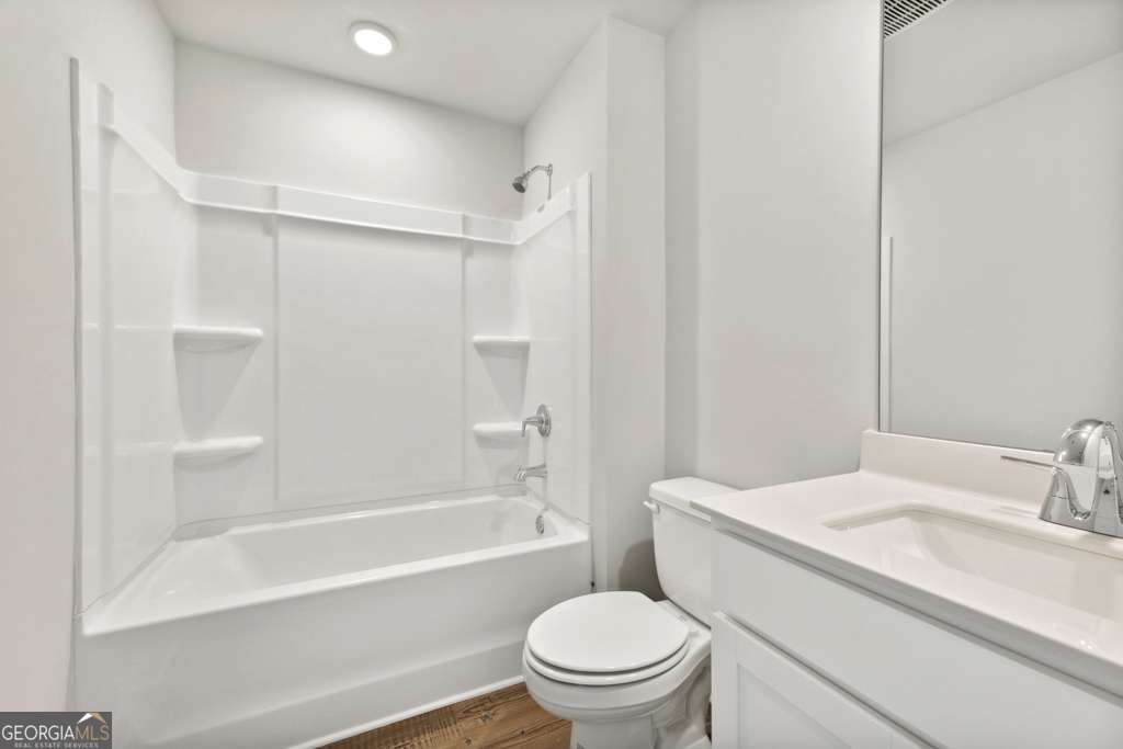 5420 Aurora Trail Flowery Branch, GA 30542 - Photo 17 of 38 a bathroom with a granite countertop toilet a sink and a bathtub