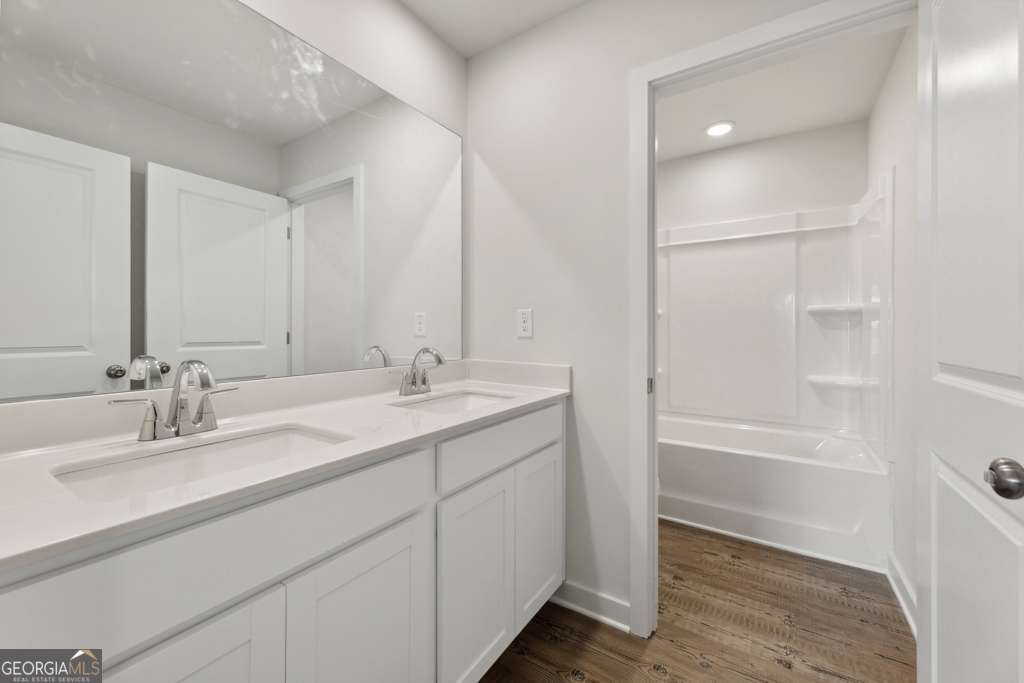 5420 Aurora Trail Flowery Branch, GA 30542 - Photo 21 of 38 a bathroom with a double vanity sink and a mirror