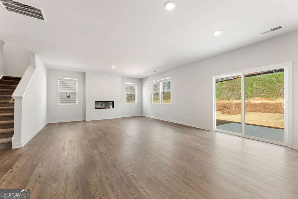 5420 Aurora Trail Flowery Branch, GA 30542 - Photo 9 of 38 an empty room with wooden floor and windows