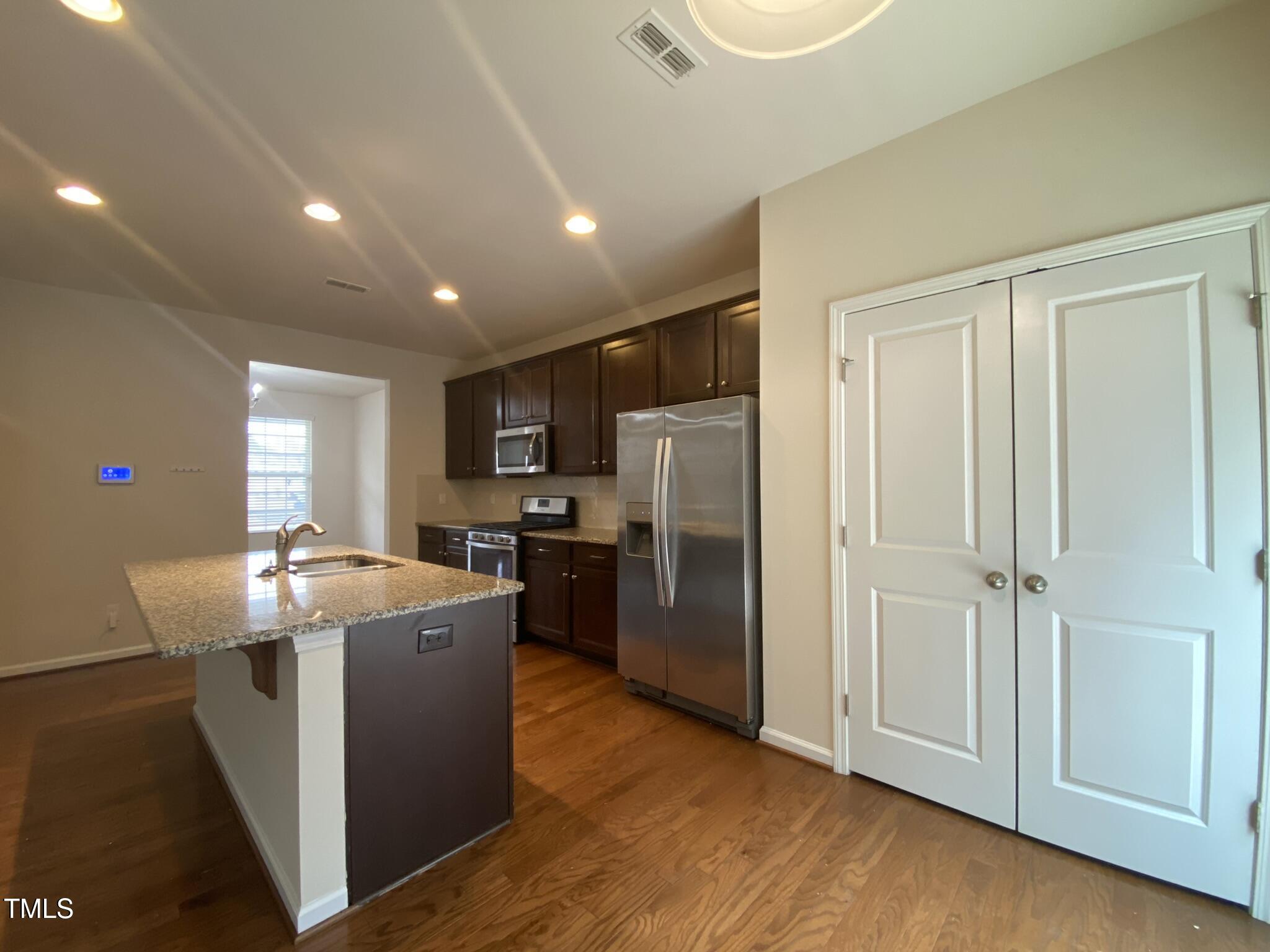 3545 Massey Ridge Court Raleigh, NC 27616 - Photo 8 of 38 a room with stainless steel appliances granite countertop a refrigerator a sink a stove a dining table and chairs