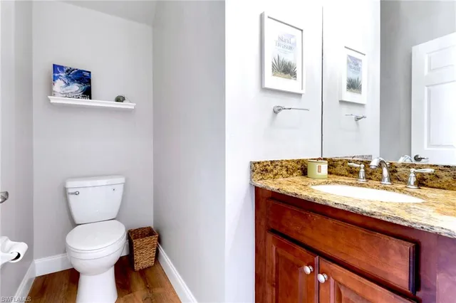 a bathroom with a granite countertop toilet sink and mirror