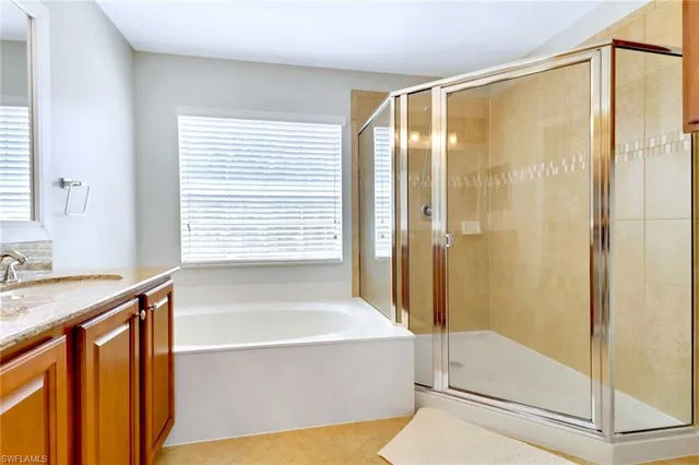 a en suite bathroom with a granite countertop sink and a mirror