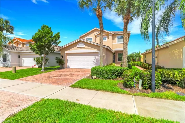 a front view of a house with a yard and potted plants
