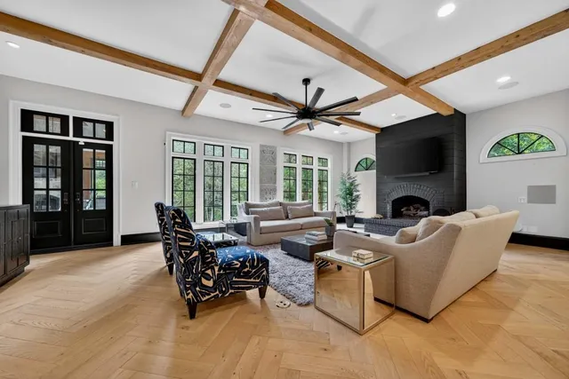 a living room with furniture kitchen view and a chandelier