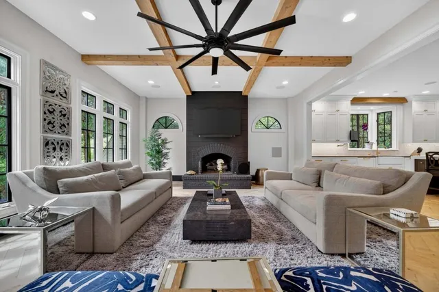 a living room with furniture a flat screen tv and kitchen view