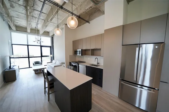a kitchen with kitchen island a counter top space wooden floor and stainless steel appliances