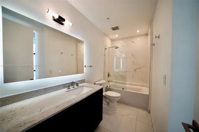 a bathroom with a double vanity sink a toilet and a shower