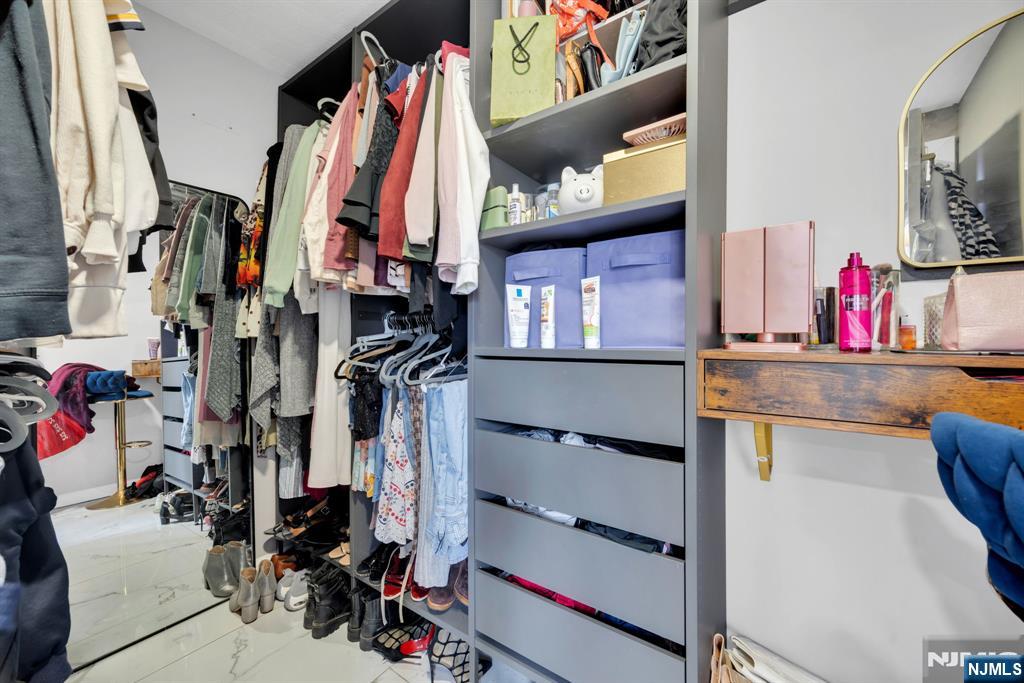 241 Orange Street Dunellen, NJ 08812 - Photo 17 of 35 a view of walk in closet with clothes and shoes