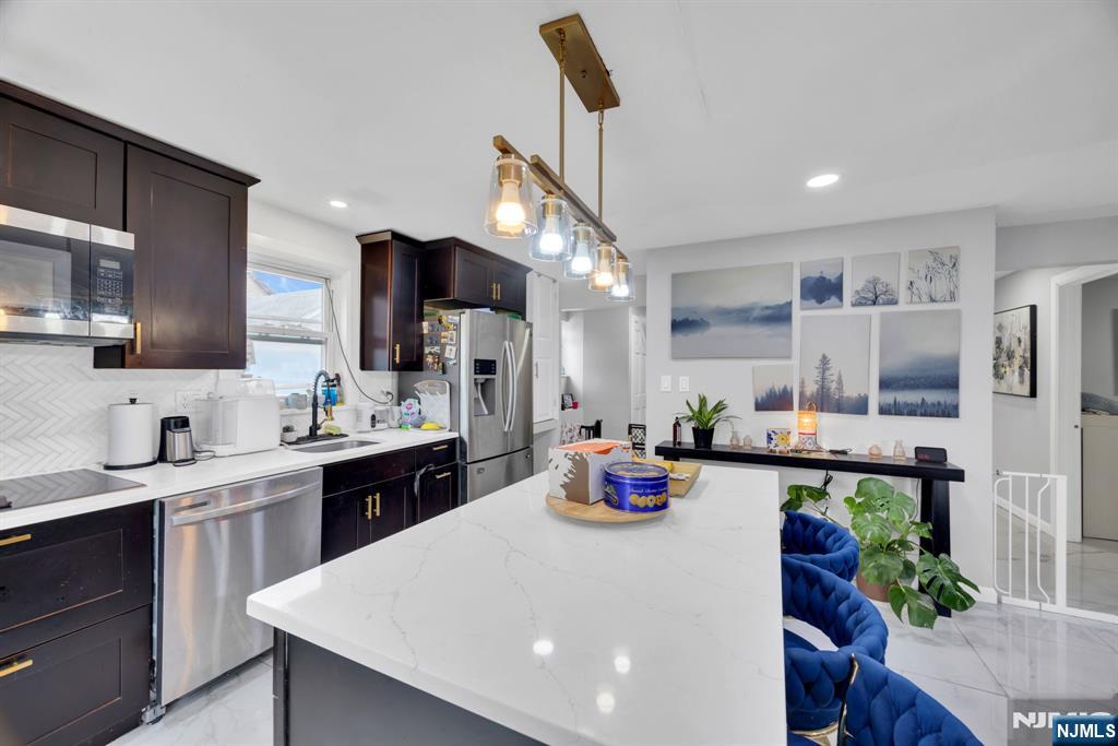 241 Orange Street Dunellen, NJ 08812 - Photo 5 of 35 a kitchen with sink a refrigerator and cabinets