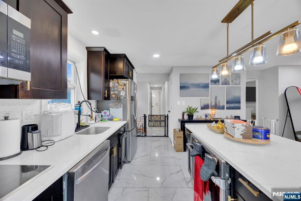 241 Orange Street Dunellen, NJ 08812 - Photo 8 of 35 a kitchen with a sink a stove and chairs