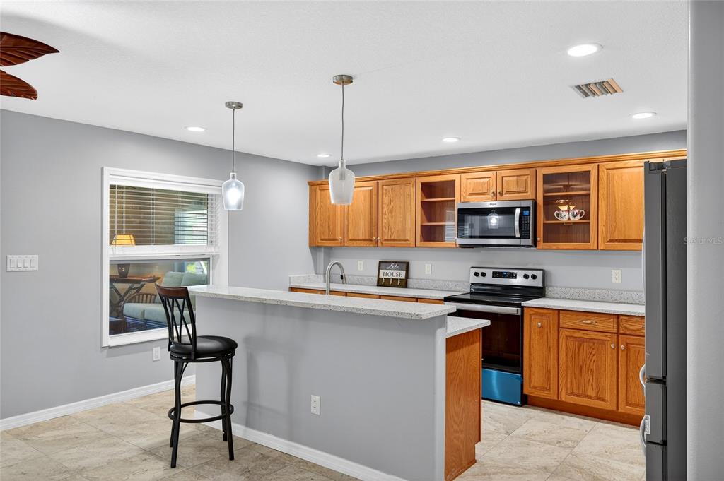 201 West Street Interlachen, FL 32148 - Photo 18 of 43 a kitchen with stainless steel appliances a sink a stove a refrigerator cabinets and a dining table