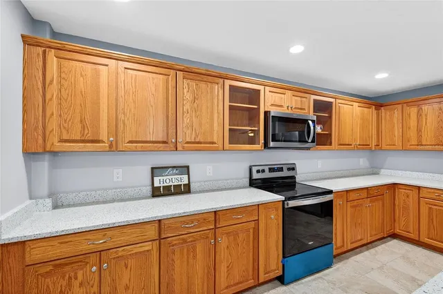 a kitchen with stainless steel appliances granite countertop white cabinets sink and a granite counter top