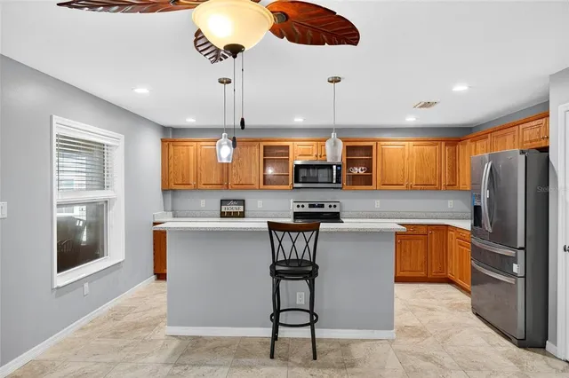 a kitchen with stainless steel appliances kitchen island a large counter top space cabinets and a window