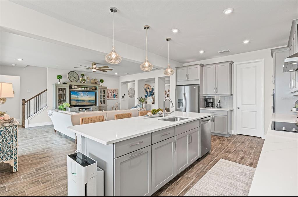 20380 Symphony Place Venice, FL 34293 - Photo 12 of 56 a large white kitchen with a stove a sink dishwasher and a refrigerator with wooden floor