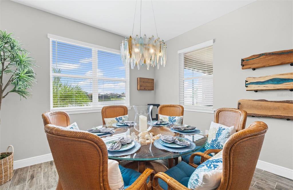 20380 Symphony Place Venice, FL 34293 - Photo 14 of 56 a dining room with furniture a chandelier and window