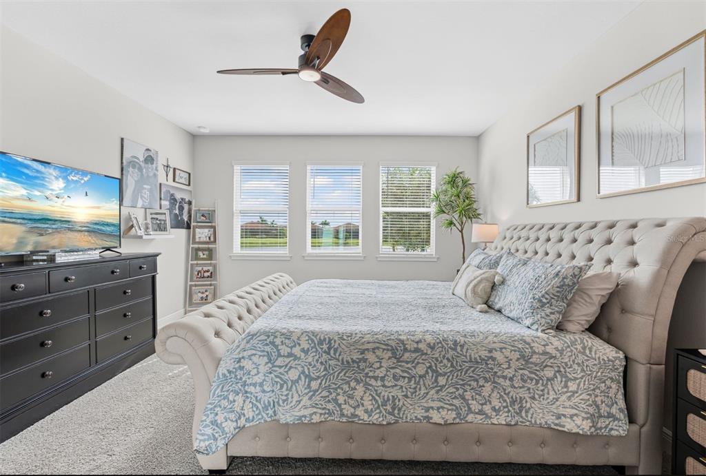 20380 Symphony Place Venice, FL 34293 - Photo 16 of 56 a bedroom with a large bed and a flat tv screen