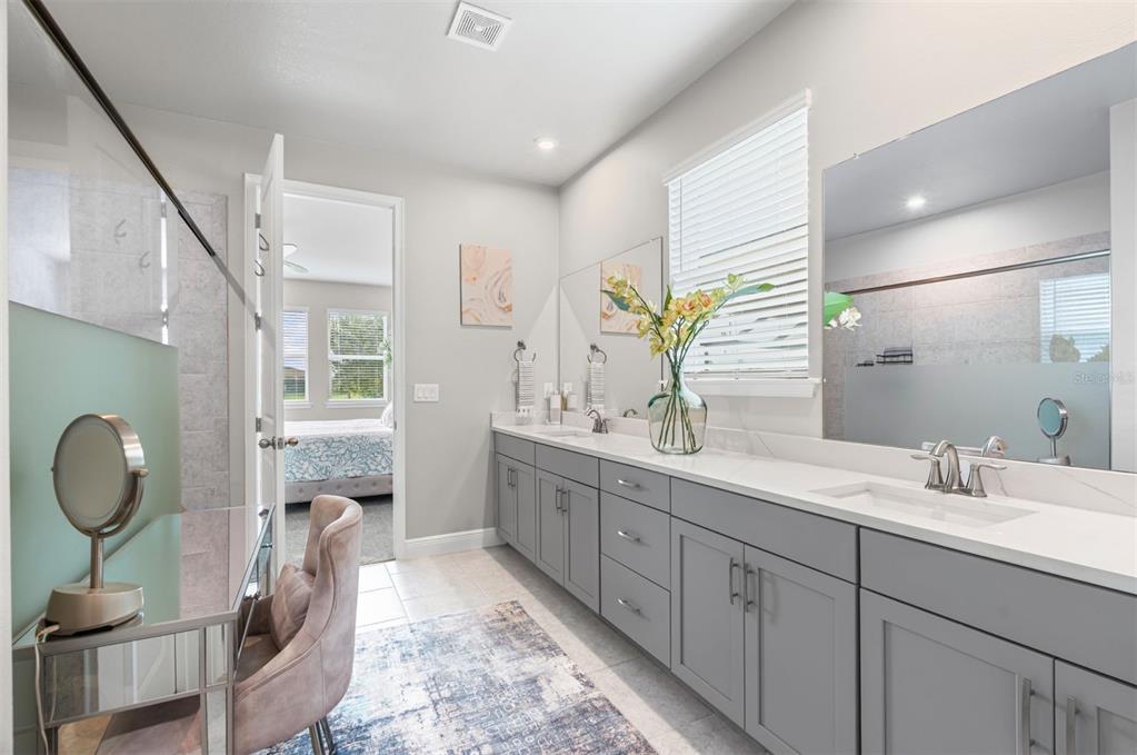 20380 Symphony Place Venice, FL 34293 - Photo 19 of 56 a spacious bathroom with a double vanity sink a mirror and a shower