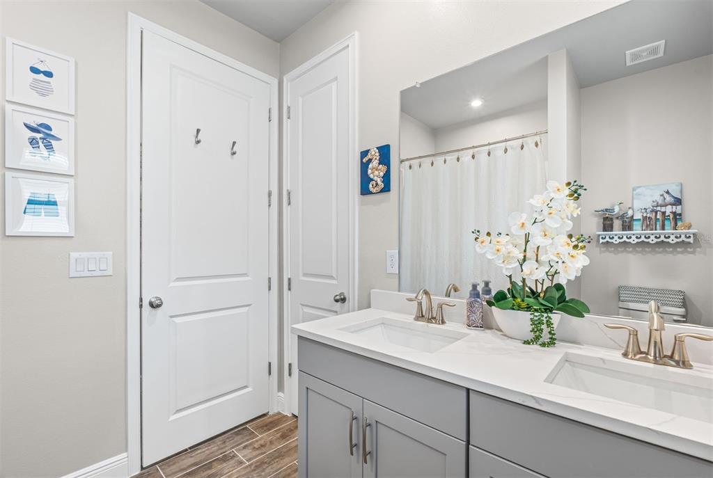 20380 Symphony Place Venice, FL 34293 - Photo 22 of 56 a bathroom with a granite countertop sink a mirror and a shower