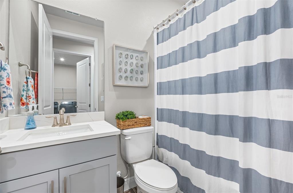 20380 Symphony Place Venice, FL 34293 - Photo 26 of 56 a bathroom with a sink a toilet a mirror and shower curtain