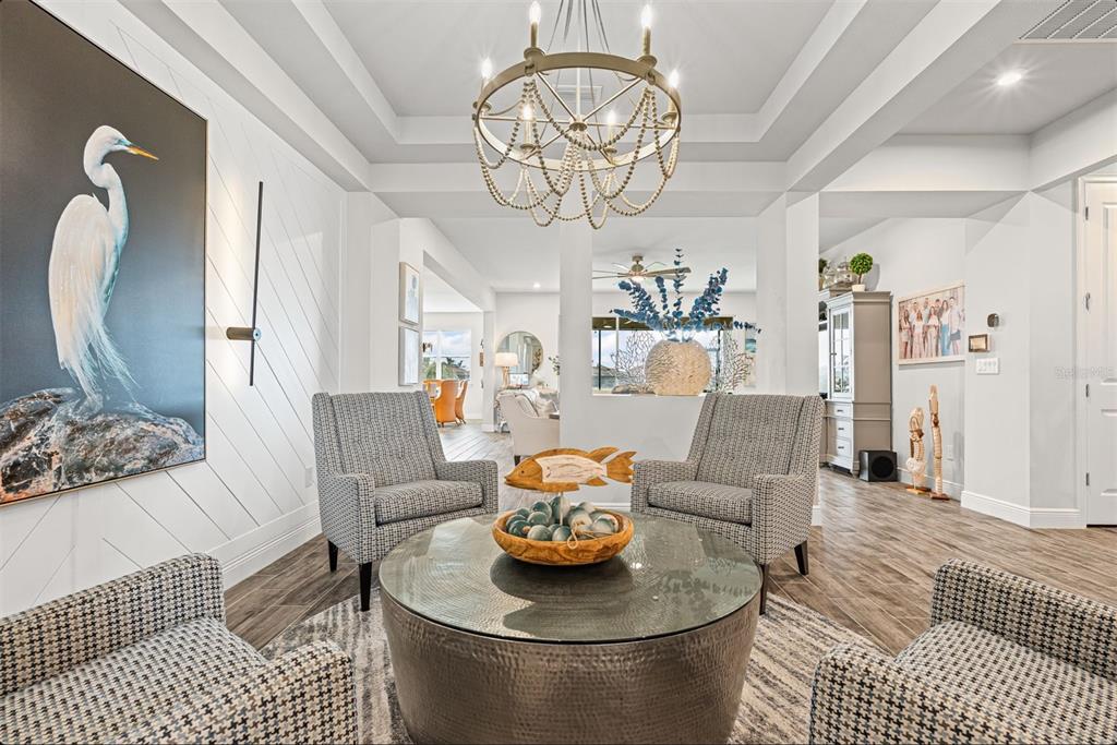 20380 Symphony Place Venice, FL 34293 - Photo 6 of 56 a living room with furniture and a chandelier
