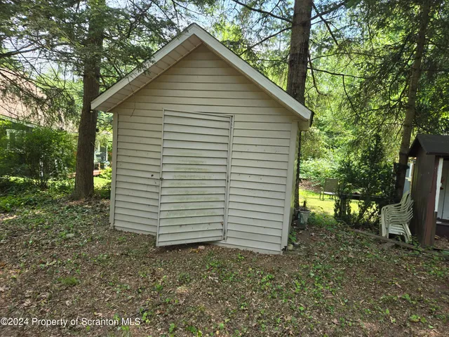 a view of a small house with large trees