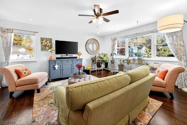 a living room with furniture a flat screen tv and a large window