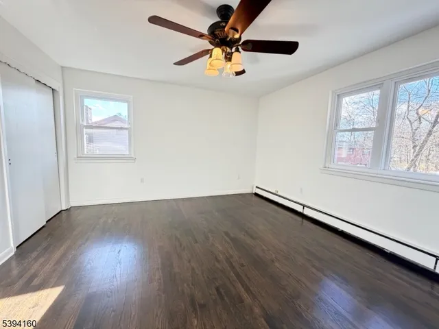 a view of a room with wooden floor and a ceiling fan