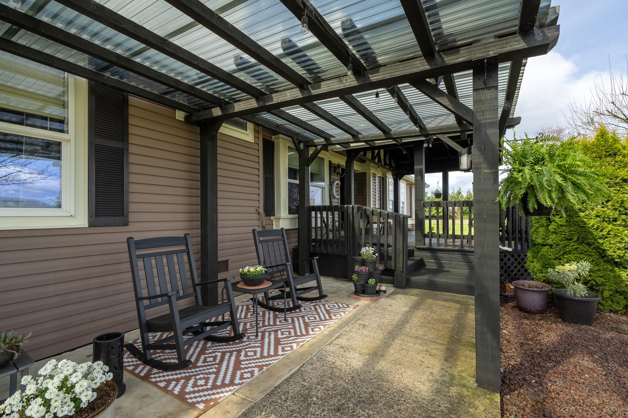 7400 South Prairie Road Tillamook, OR 97141 - Photo 27 of 62 a view of a porch with chairs and potted plants