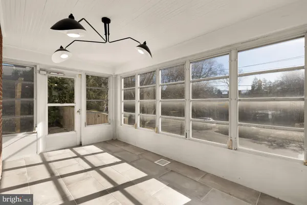 a view of empty room with windows and chandelier