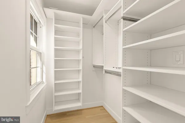 a view of walk in closet with empty racks