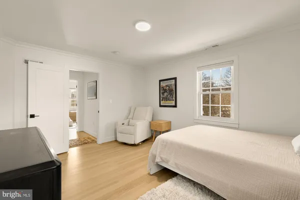a spacious bedroom with a bed and wooden floor