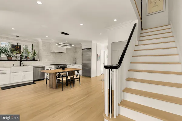 a open kitchen with stainless steel appliances kitchen island hardwood floor and a sink