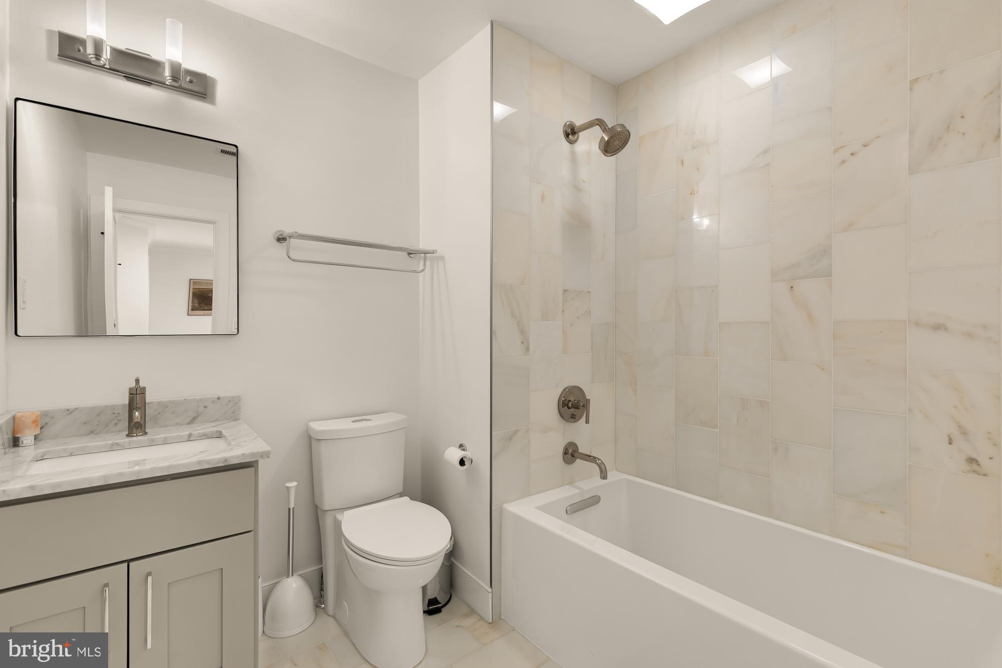 4105 17th Street Northwest Washington, DC 20011 - Photo 21 of 31 a bathroom with a toilet a sink a mirror a bathtub and vanity