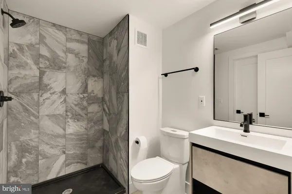 a bathroom with a sink a toilet and shower