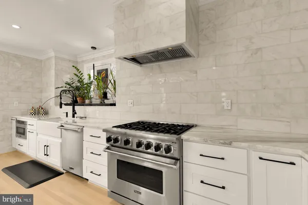 a kitchen with white cabinets and appliances