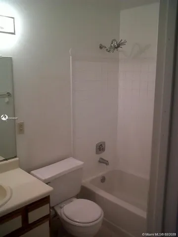 a white toilet and tub next to a bathroom sink