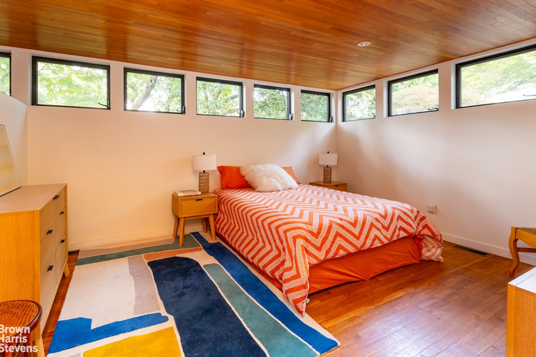 712 Ladd Road Bronx, NY 10471 - Photo 13 of 34 a bedroom with a bed and wooden floor